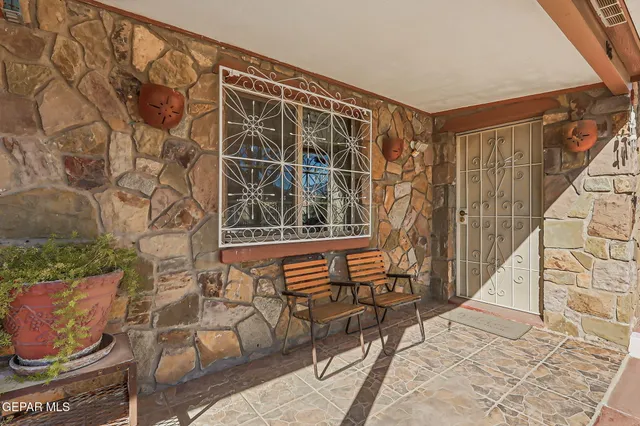 a view of a white house with a large tree and wooden fence