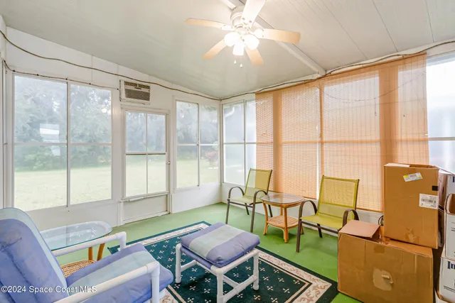 a living room with furniture and a floor to ceiling window
