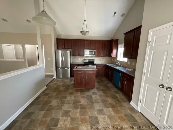 a kitchen with stainless steel appliances granite countertop a stove refrigerator sink and cabinets