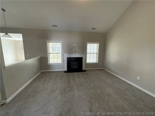 en empty room with windows and fireplace