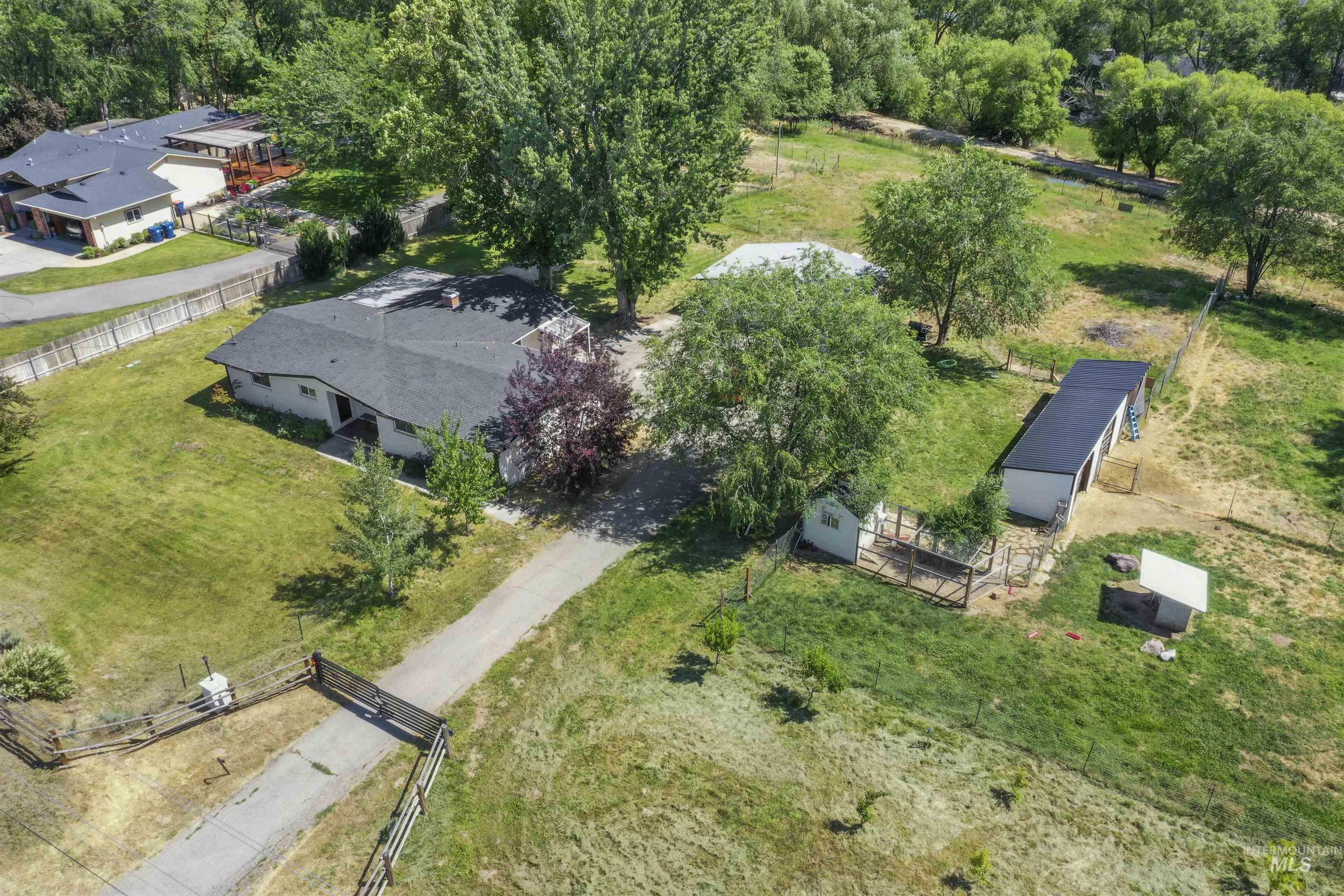355 East Beacon Light Road Eagle, ID 83616 - Photo 46 of 47 Spacious property featuring a single-story residence with a dark shingled roof, a gravel driveway, and multiple outbuildings