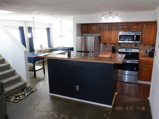 a kitchen with stainless steel appliances a stove a refrigerator and a stove