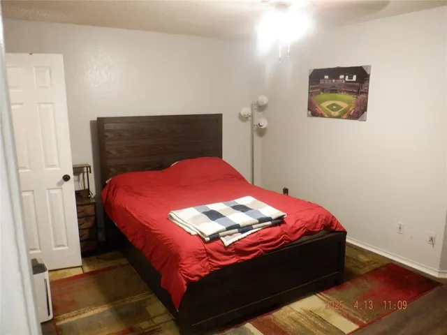 a bedroom with a bed and a painting on the wall