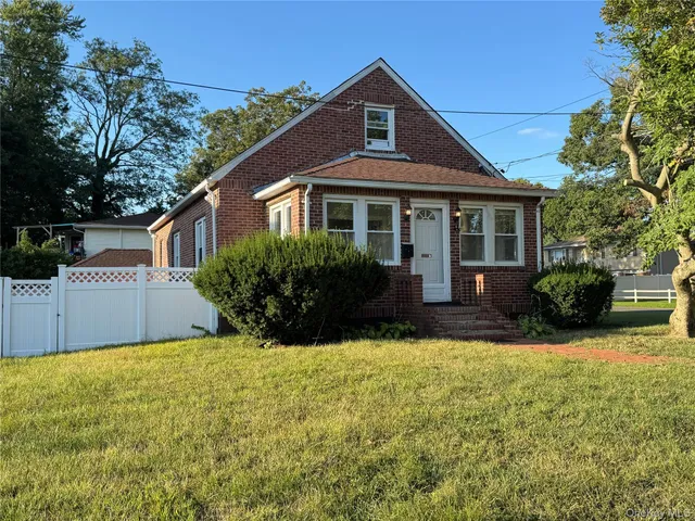 a front view of a house with yard and green space