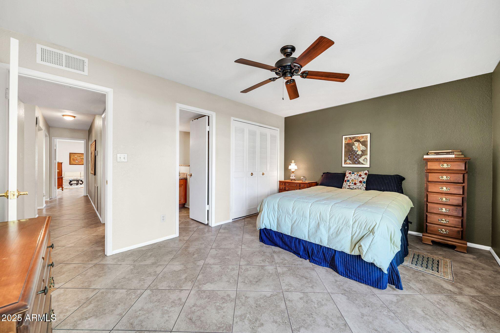 25621 Cordova Lane Rio Verde, AZ 85263 - Photo 28 of 42 a spacious bedroom with a bed and a chandelier