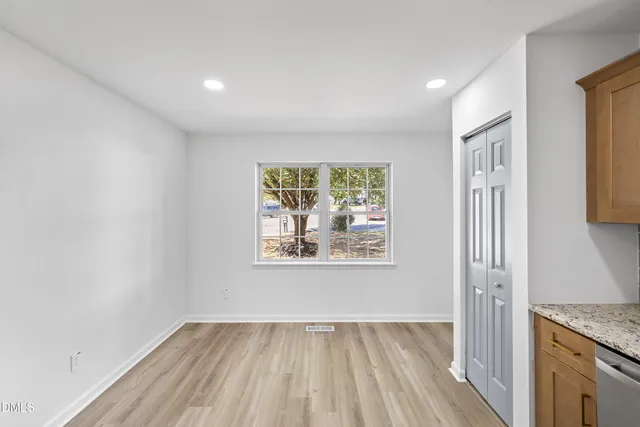 an empty room with wooden floor and a window