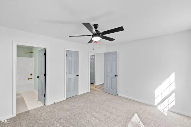 a view of a livingroom with a ceiling fan & window