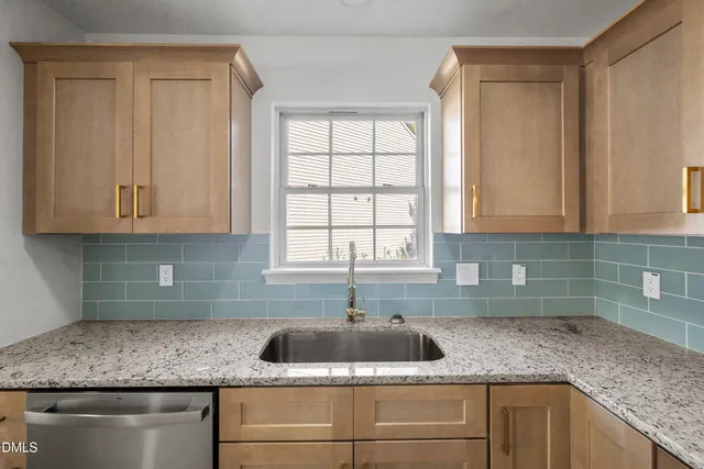 a kitchen with stainless steel appliances granite countertop white cabinets and a sink