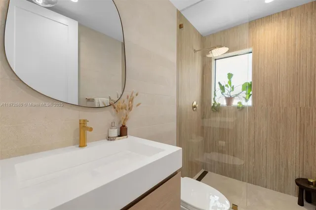 a bathroom with a sink a toilet and shower