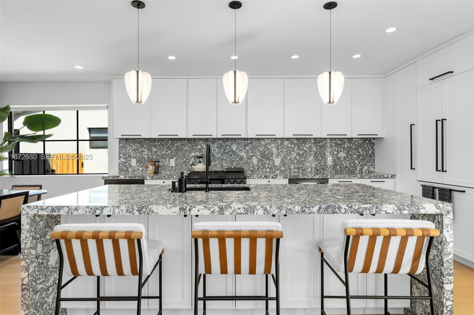8934 Garland Avenue Surfside, FL 33154 - Photo 5 of 20 a kitchen with stainless steel appliances granite countertop a sink a stove a dining table and chairs