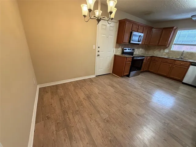 a kitchen with wooden floor and window
