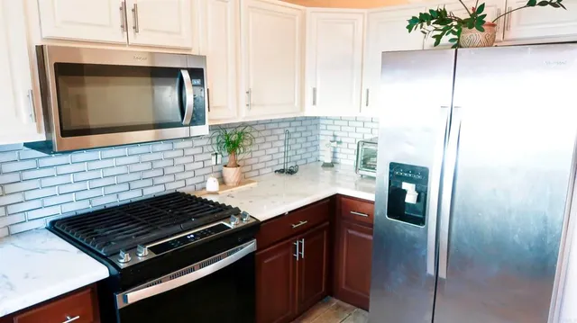 a kitchen with stainless steel appliances granite countertop a stove and a microwave