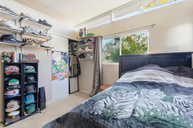 a bedroom with a bed a window and closet