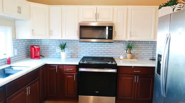 a kitchen with stainless steel appliances granite countertop a sink stove and cabinets
