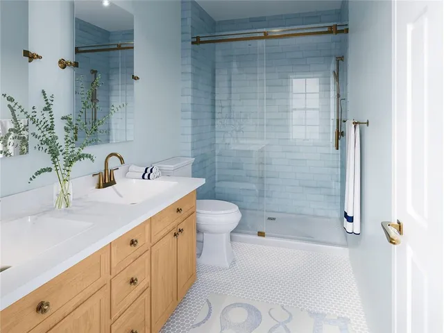 a bathroom with a granite countertop sink a toilet and shower