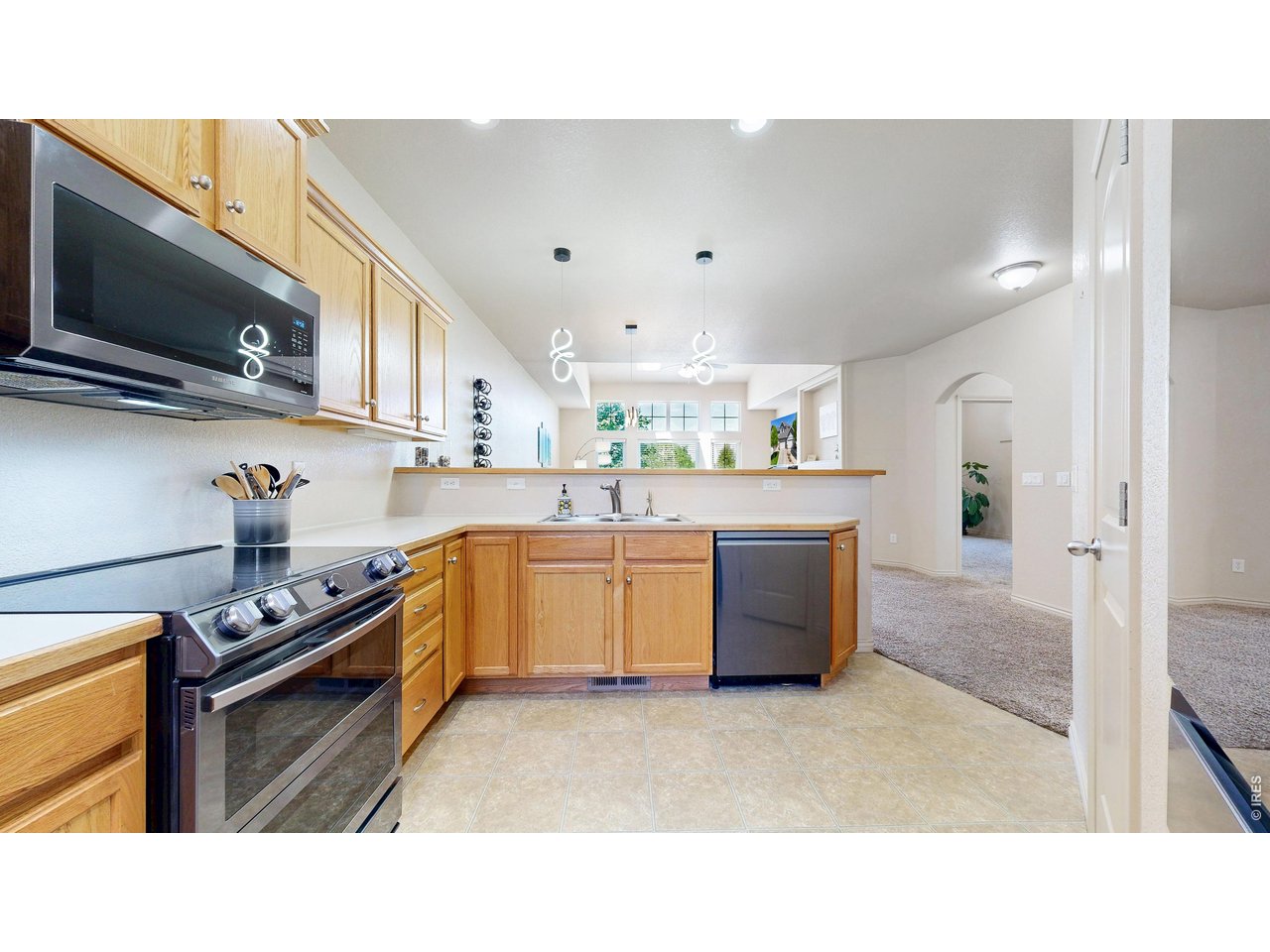 4672 West 20th Road, Unit 413 Greeley, CO 80634 - Photo 13 of 37 a kitchen with kitchen island stainless steel appliances a sink a stove and a refrigerator