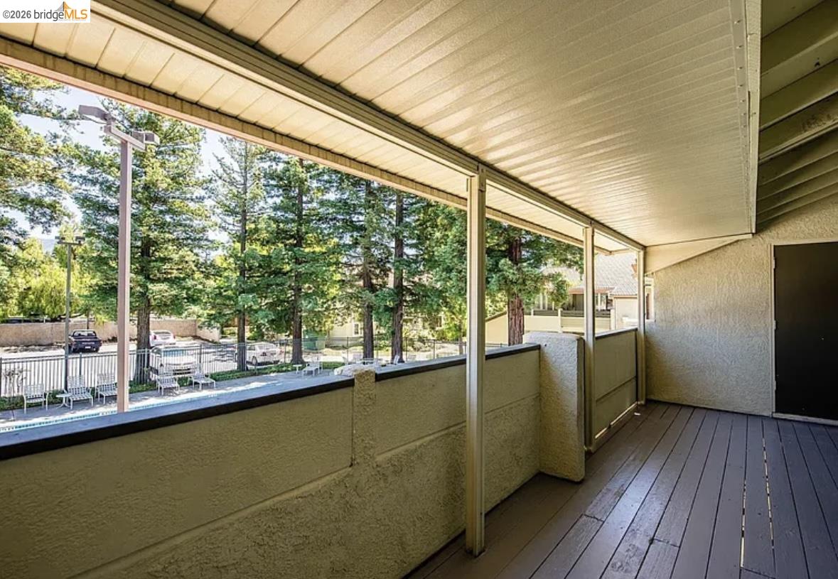 1505 Kirker Pass Road, Unit 214 Concord, CA 94521 - Photo 27 of 55 Covered balcony featuring wood-finish flooring, stucco walls, and a private exterior door