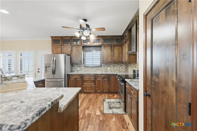 a large kitchen with kitchen island granite countertop a large counter top appliances and cabinets