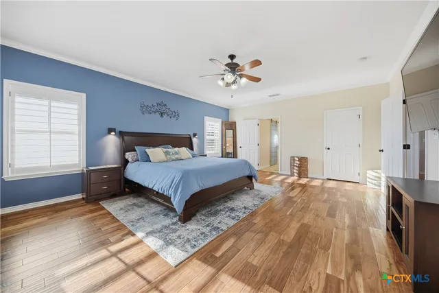 a bedroom with a large bed chandelier and a window