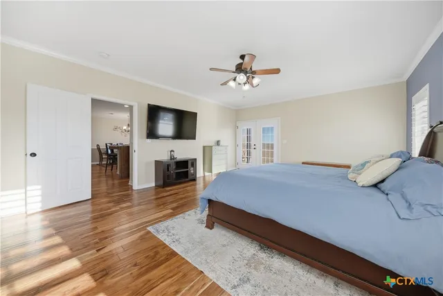 a spacious bedroom with a bed and a flat screen tv