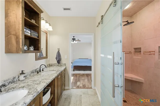 a bathroom with a granite countertop sink and a mirror