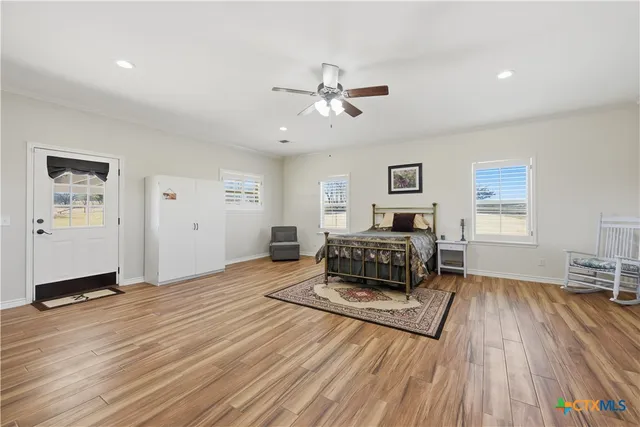 a bedroom with a bed ceiling fan and a window