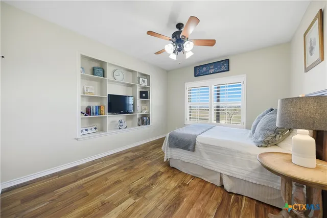 a bedroom with a large bed chandelier and a window