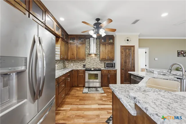 a kitchen with stainless steel appliances granite countertop a sink refrigerator and cabinets