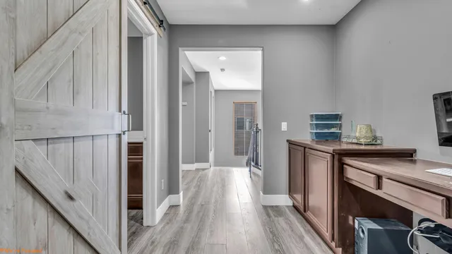 a view of a hallway with wooden floor and staircase