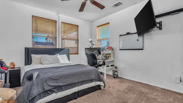 a bedroom with a bed a flat screen tv and window