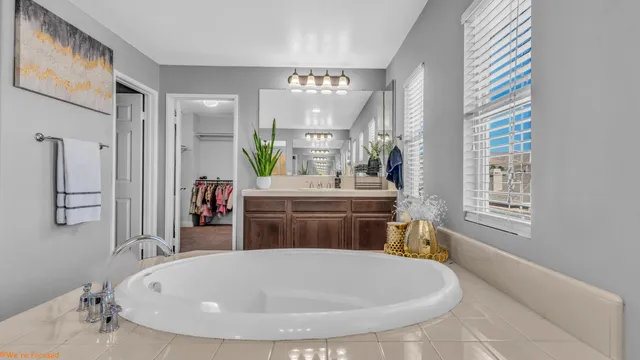 a bathroom with a tub sink and mirror