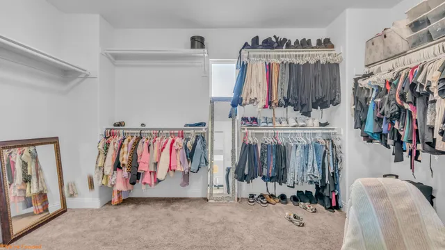 a view of walk in closet with clothes