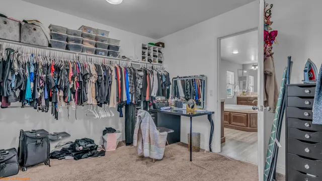 a view of walk in closet with clothes and shoes