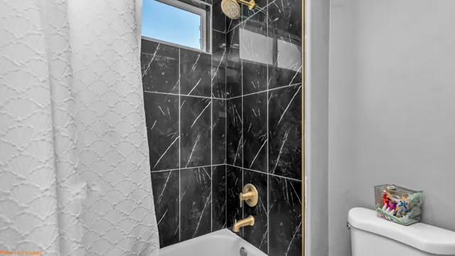 a bathroom with a toilet and a shower