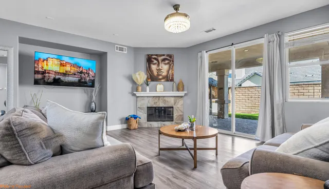 a living room with furniture a fireplace and a flat screen tv