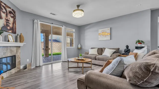 a living room with furniture a fireplace and a floor to ceiling window