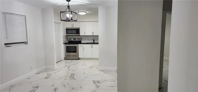 a view of a kitchen with microwave and refrigerator