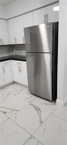 a kitchen with stainless steel appliances a refrigerator and microwave