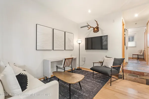 a living room with furniture a flat screen tv and kitchen view