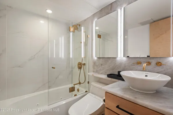 a bathroom with a double vanity sink toilet and shower