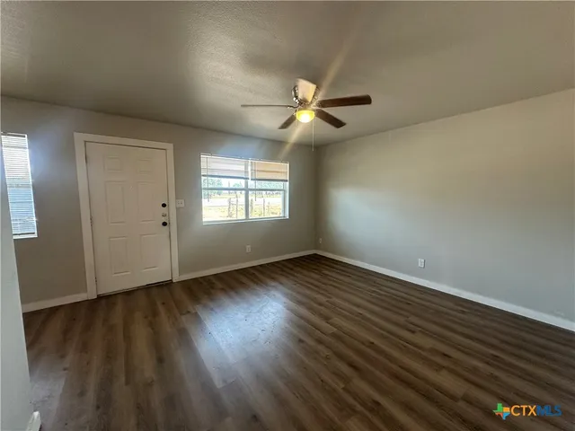 a kitchen with a refrigerator and white cabinets