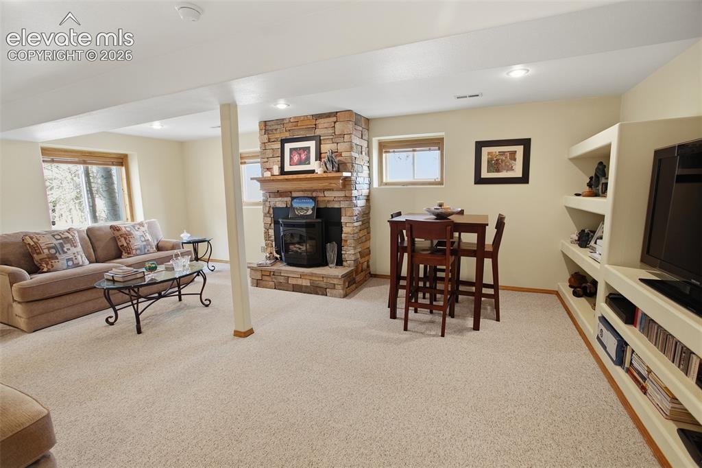 877 North Mountain Estates Road Florissant, CO 80816 - Photo 9 of 23 a living room with furniture a dining table and a fireplace