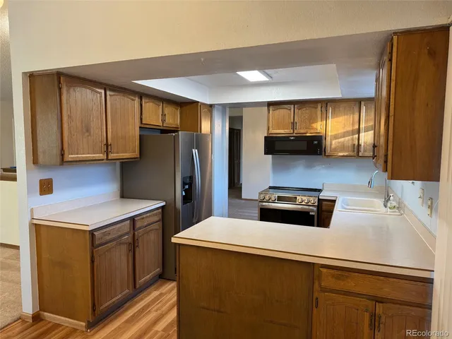 a kitchen with stainless steel appliances a refrigerator sink and microwave