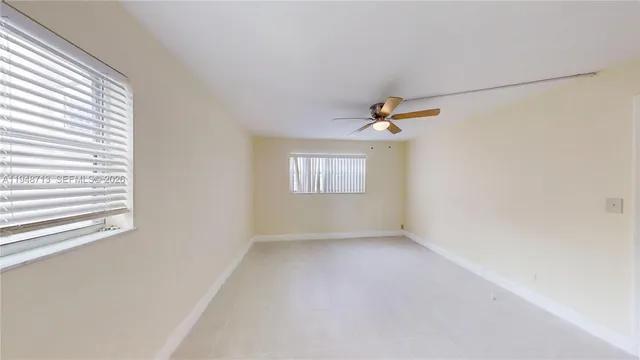an empty room with a window and a ceiling fan view