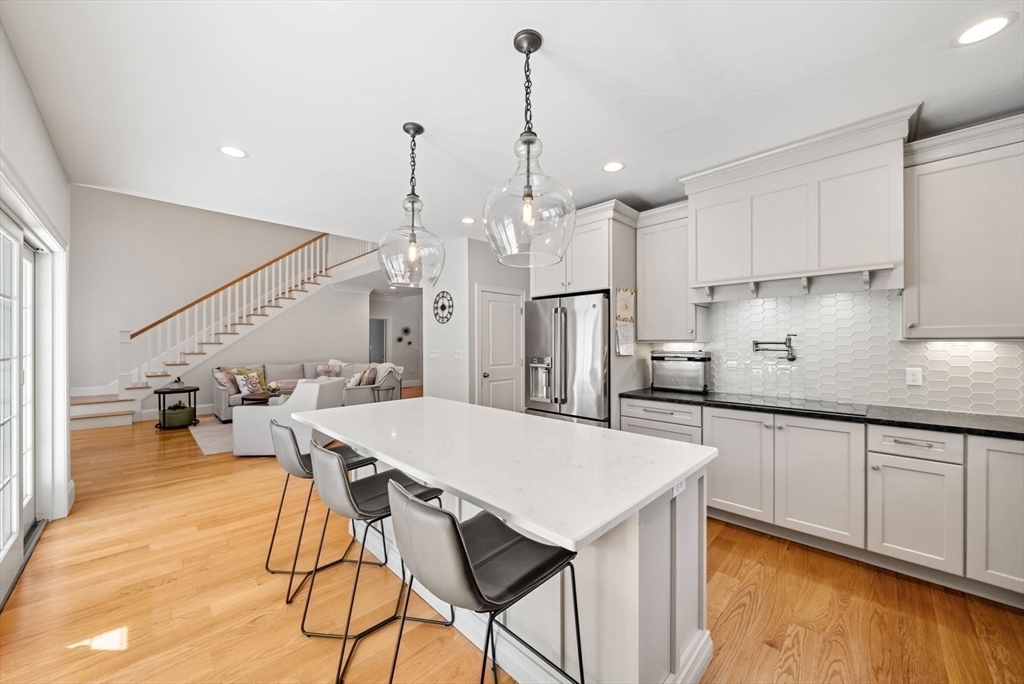 185 Bailey Street Canton, MA 02021 - Photo 14 of 42 a kitchen with stainless steel appliances kitchen island a table chairs sink and cabinets