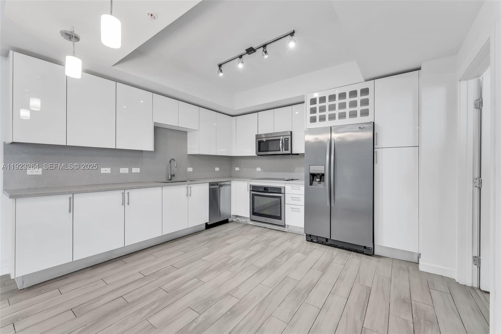 999 Southwest 1st Avenue, Unit 2801 Miami, FL 33130 - Photo 2 of 42 a kitchen with stainless steel appliances granite countertop a refrigerator a sink dishwasher a stove and white countertops with wooden floor
