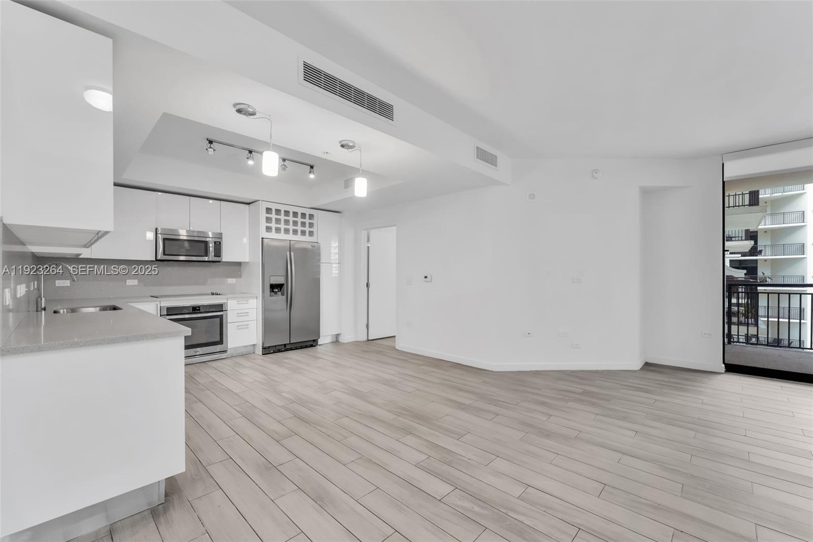 999 Southwest 1st Avenue, Unit 2801 Miami, FL 33130 - Photo 3 of 42 an empty room with wooden floor and windows