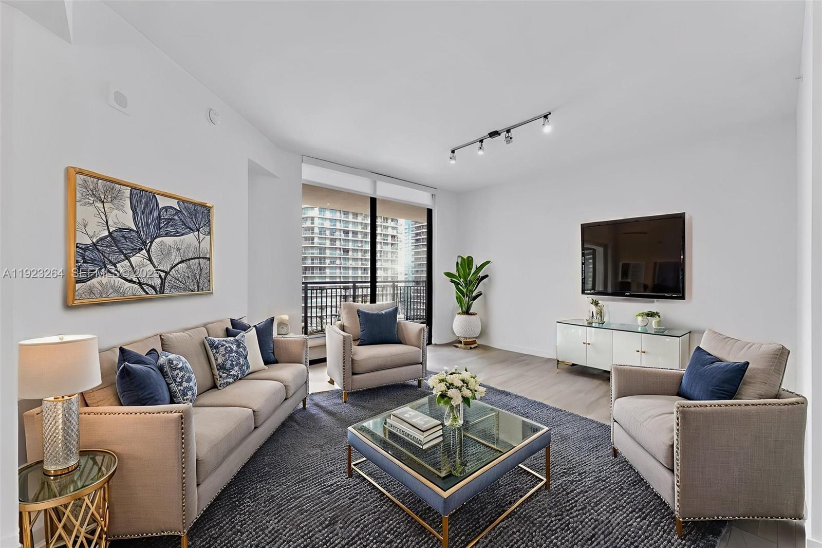 999 Southwest 1st Avenue, Unit 2801 Miami, FL 33130 - Photo 6 of 42 a living room with furniture and a flat screen tv