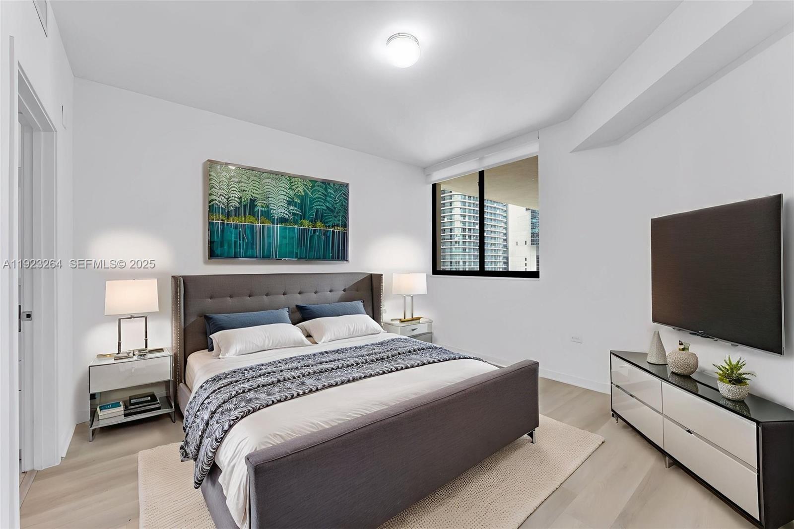999 Southwest 1st Avenue, Unit 2801 Miami, FL 33130 - Photo 8 of 42 a bedroom with a bed and a flat screen tv