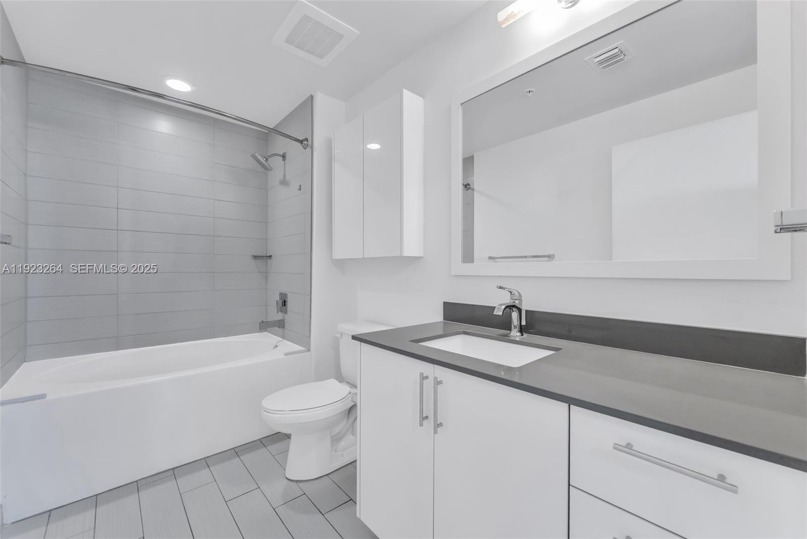 999 Southwest 1st Avenue, Unit 2801 Miami, FL 33130 - Photo 9 of 42 a bathroom with a sink a toilet and a bathtub